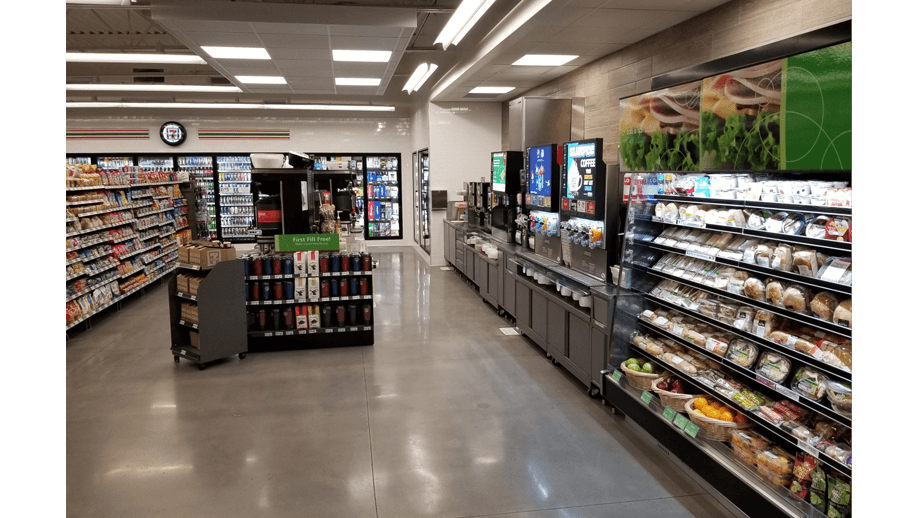 Indoor image image of 7-11 showing deli fridge display and soda machines.