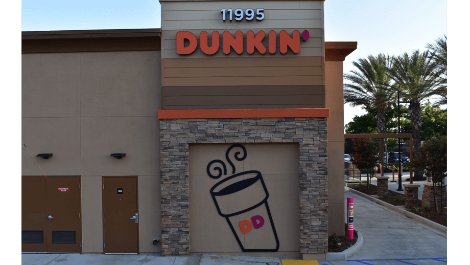 Outdoor image of the back of Dunkin Donuts showing sign and artwork.