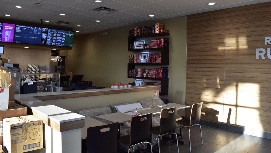 Indoor image of Dunkin Donuts showing the dining area and main menu screens.