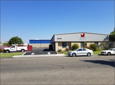 Outdoor image of the West Coast Construction buiding facade with gray roofing and beige walls. 