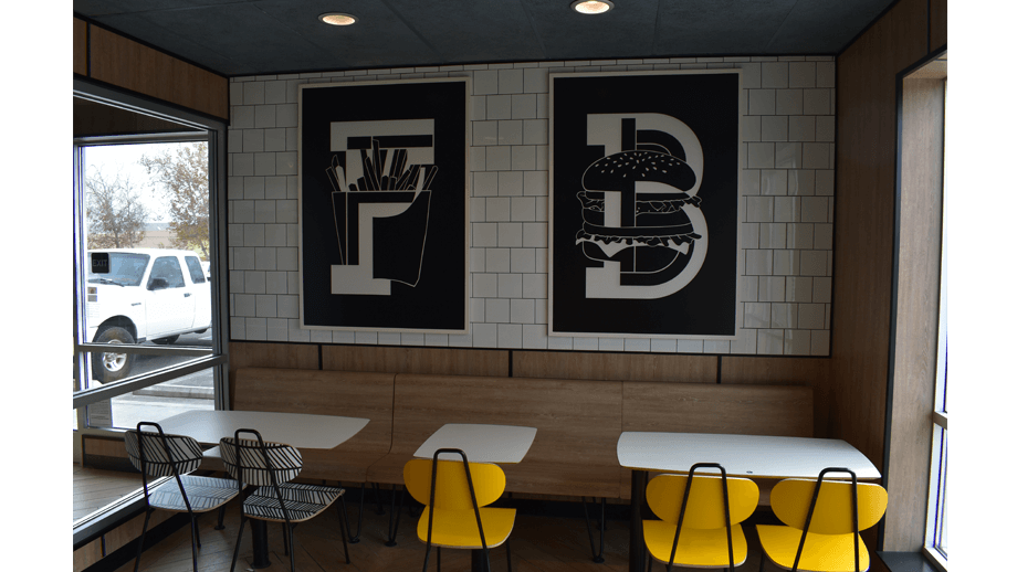 Indoor image of McDonalds showing the dining area's artwork showing burgers and fries prints.