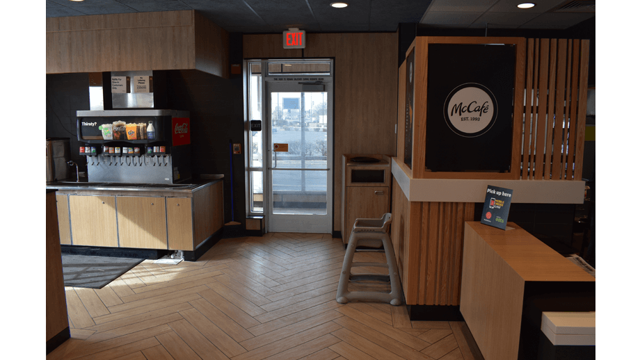 Indoor image of McDonalds showing the exit and soda machine.