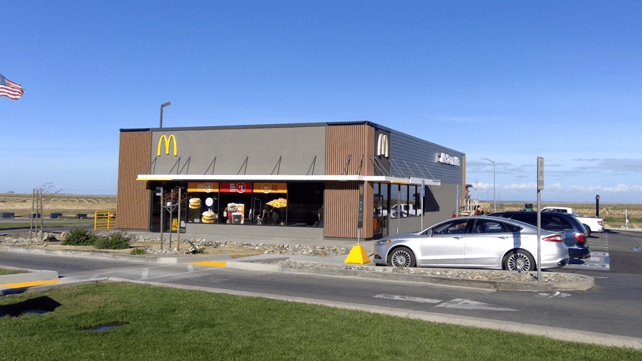 Outdoor image of McDonalds showing the main entrance and parking lot.