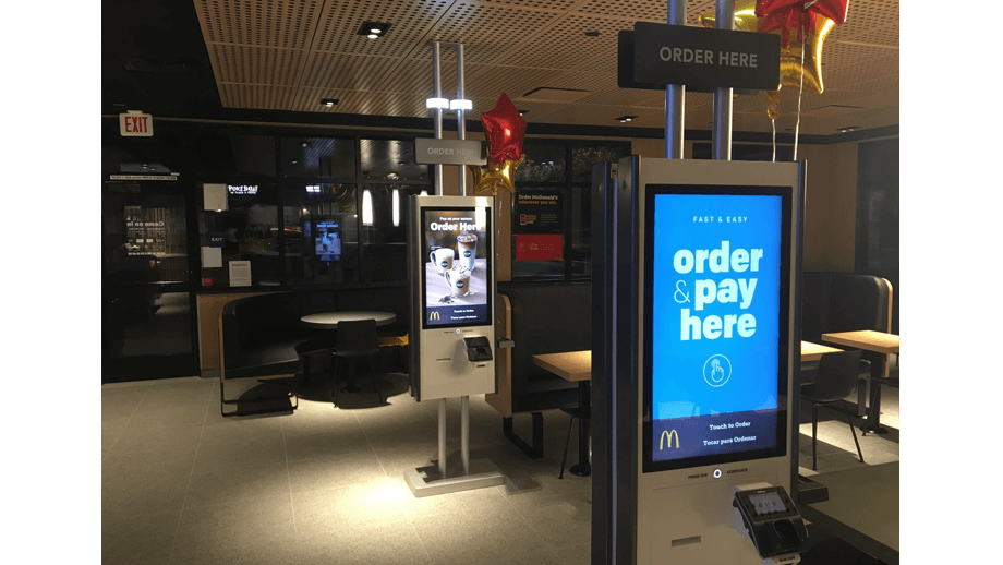 Indoor image of McDonalds showing order kiosks.